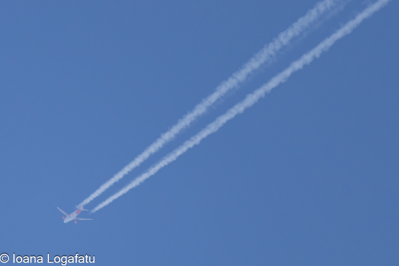 Contrails tracing the clear blue sky above